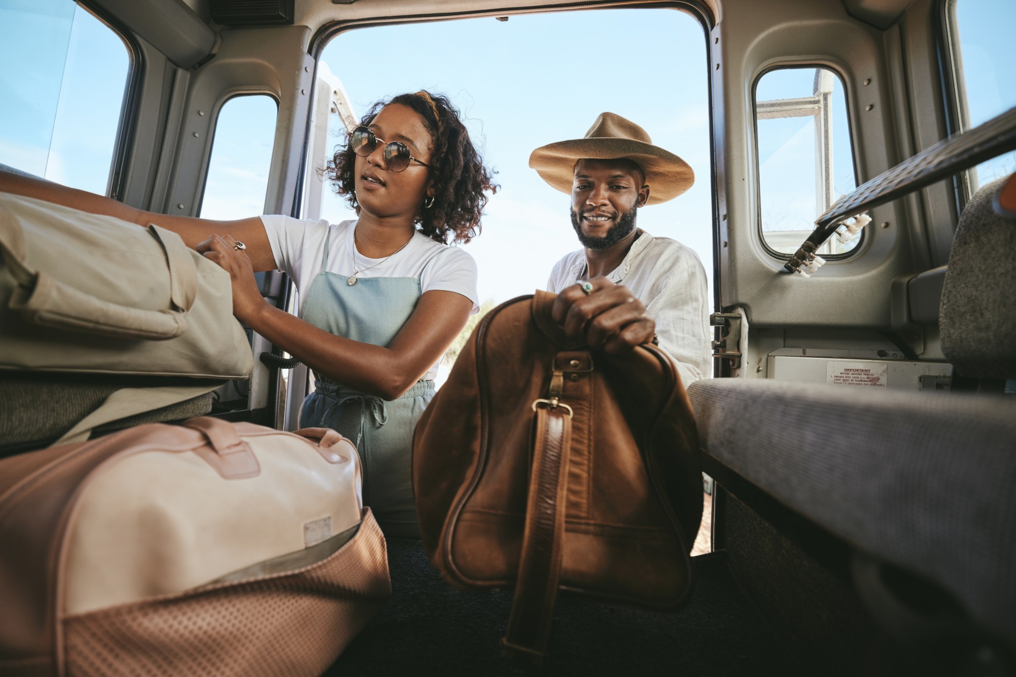 Two travelers loading bags into a van