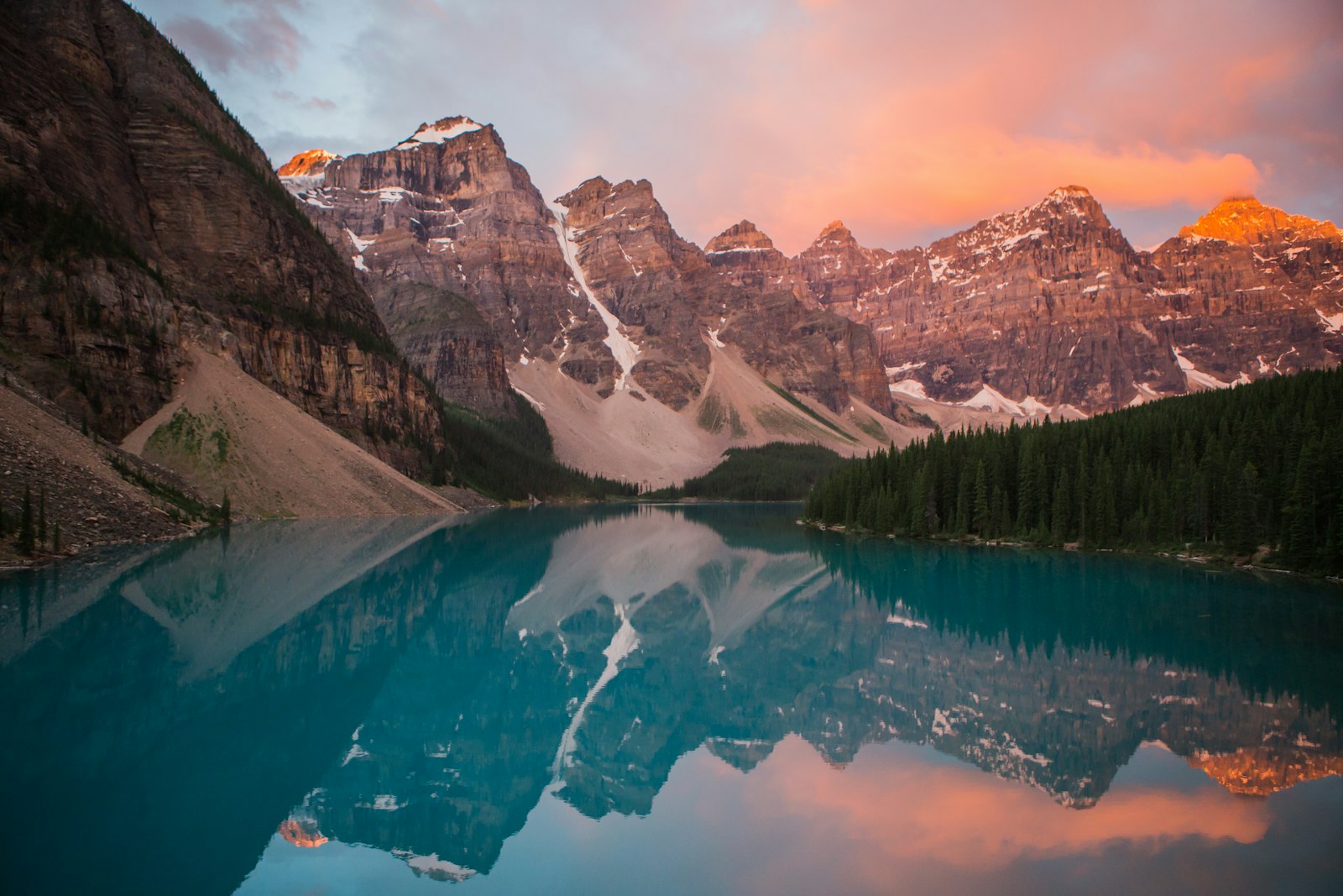 Sunrise light over a turquoise alpine lake and mountain range